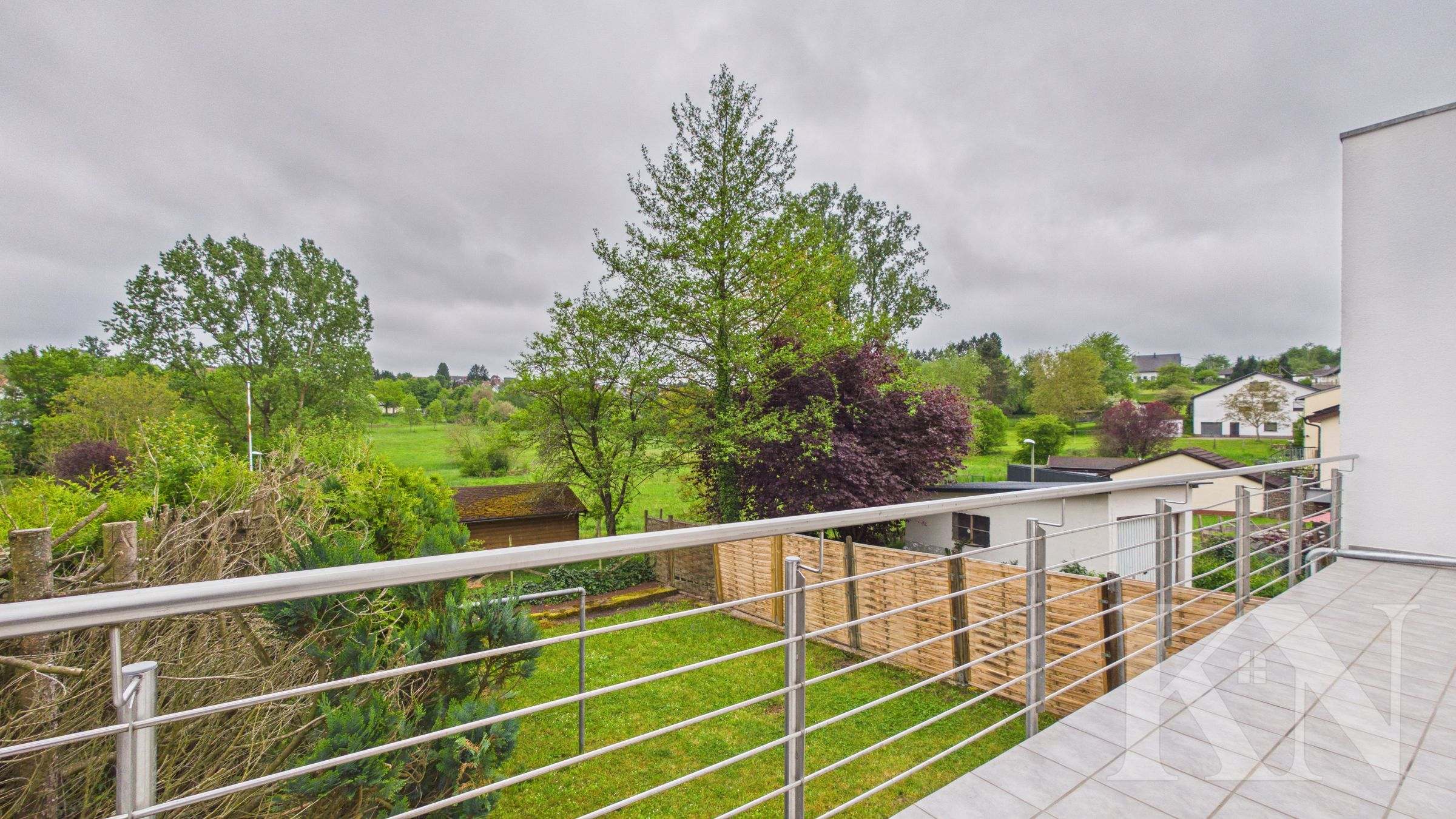 Balkon mit Blick über den Garten ins Grüne
